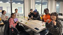 Students sitting around a large table enjoying games